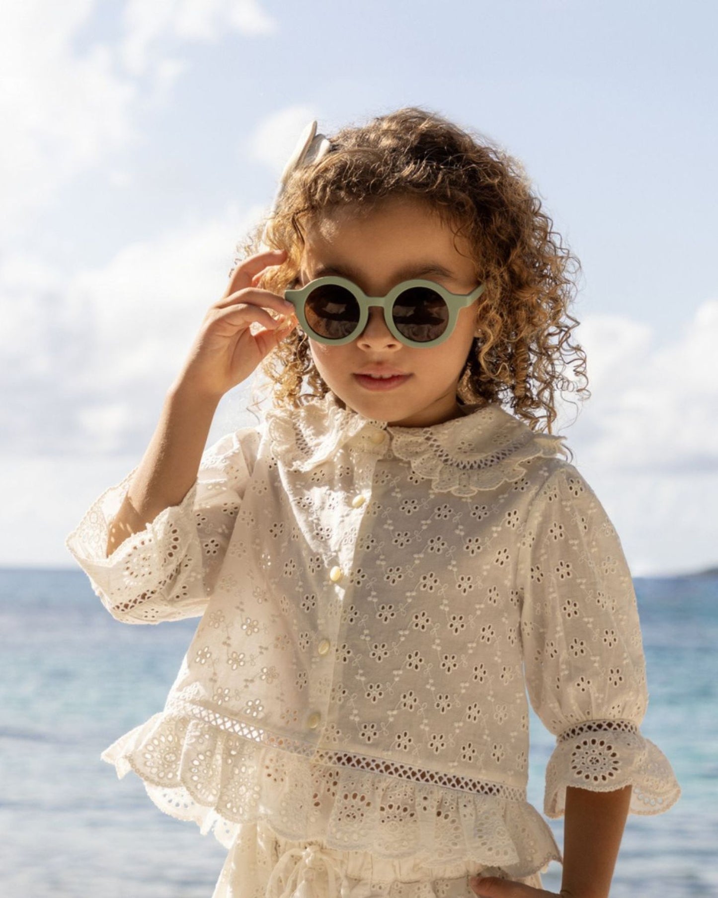Early Sunday, Iris Blouse in Ivory color, made from All-Over Eyelet Embroidered Cotton Schifflie fabric, featuring relaxed fit with delicate detailing for a timeless and feminine look, shown in a front view of model wearing it