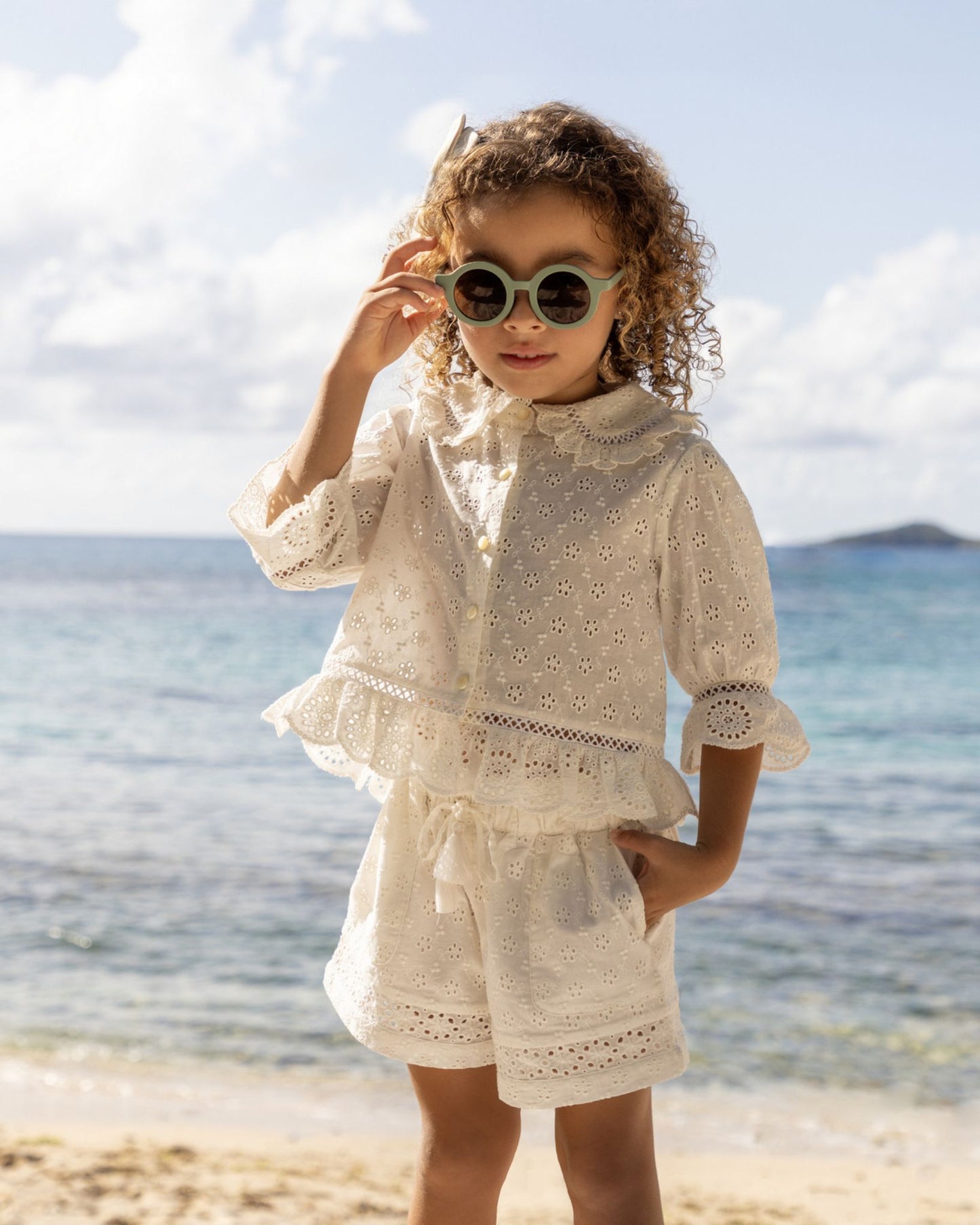 Early Sunday, Iris Blouse in Ivory color, made from All-Over Eyelet Embroidered Cotton Schifflie fabric, featuring relaxed fit with delicate detailing for a timeless and feminine look, shown in a front view of model wearing it