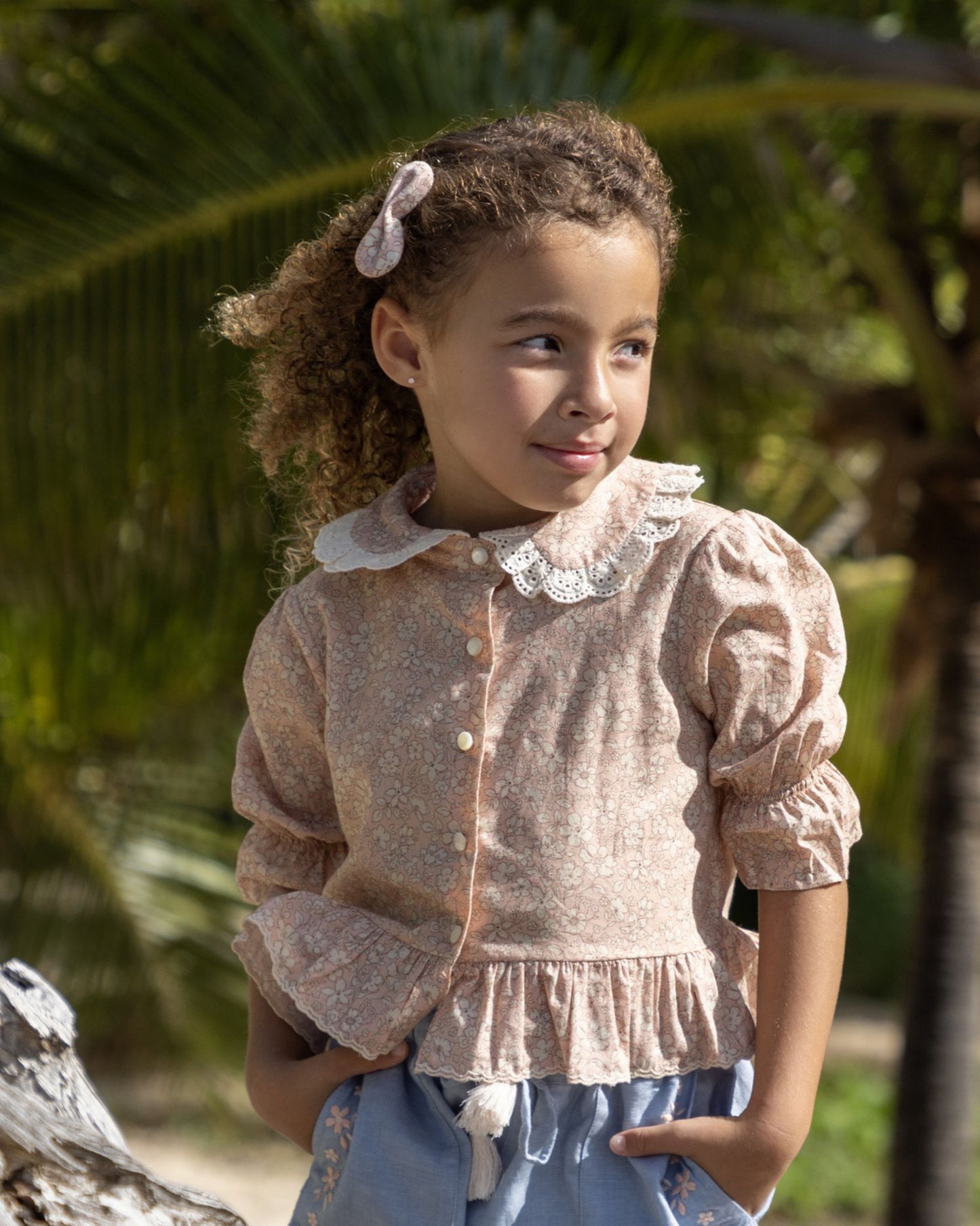 Early Sunday, Iris Blouse in Garden Flowers print, made from Printed Cotton Cambric fabric, featuring relaxed fit with delicate detailing for a timeless and feminine look, shown in a close-up side view of a model wearing it