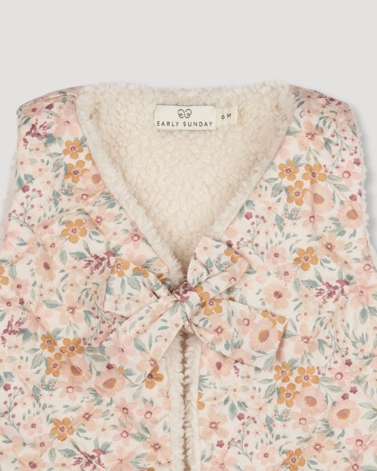 Early Sunday, Jilly Gilet in Floral print, made from Printed 60s Cotton Satin fabric, featuring a sleeveless gilet design with soft padding, shown in a closeup flat-lay view