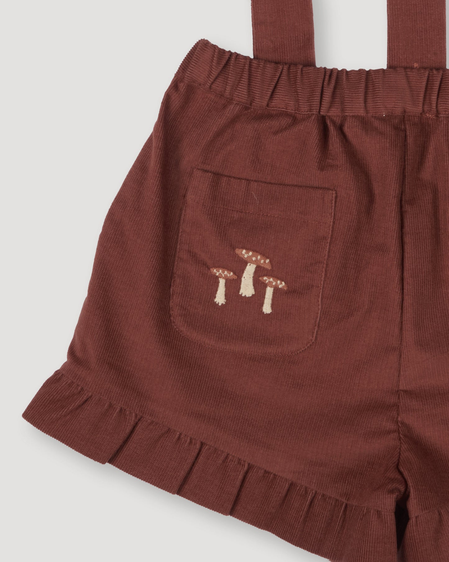 Early Sunday, Joseph Short Dungaree in Caramel, made from Cotton Corduroy fabric, featuring short dungaree with adjustable straps, shown in a close-up of print