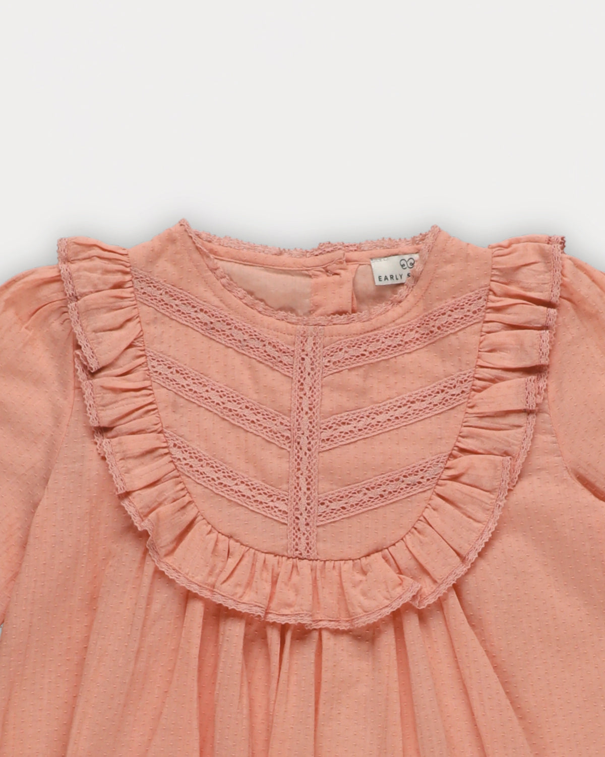 Early Sunday, Lauren Blouse in Blush, made from Cotton Jeera Dobby Voile fabric, featuring layered lace-trimmed ruffles and delicate pintuck detailing on the yoke, shown in a closeup flat-lay view