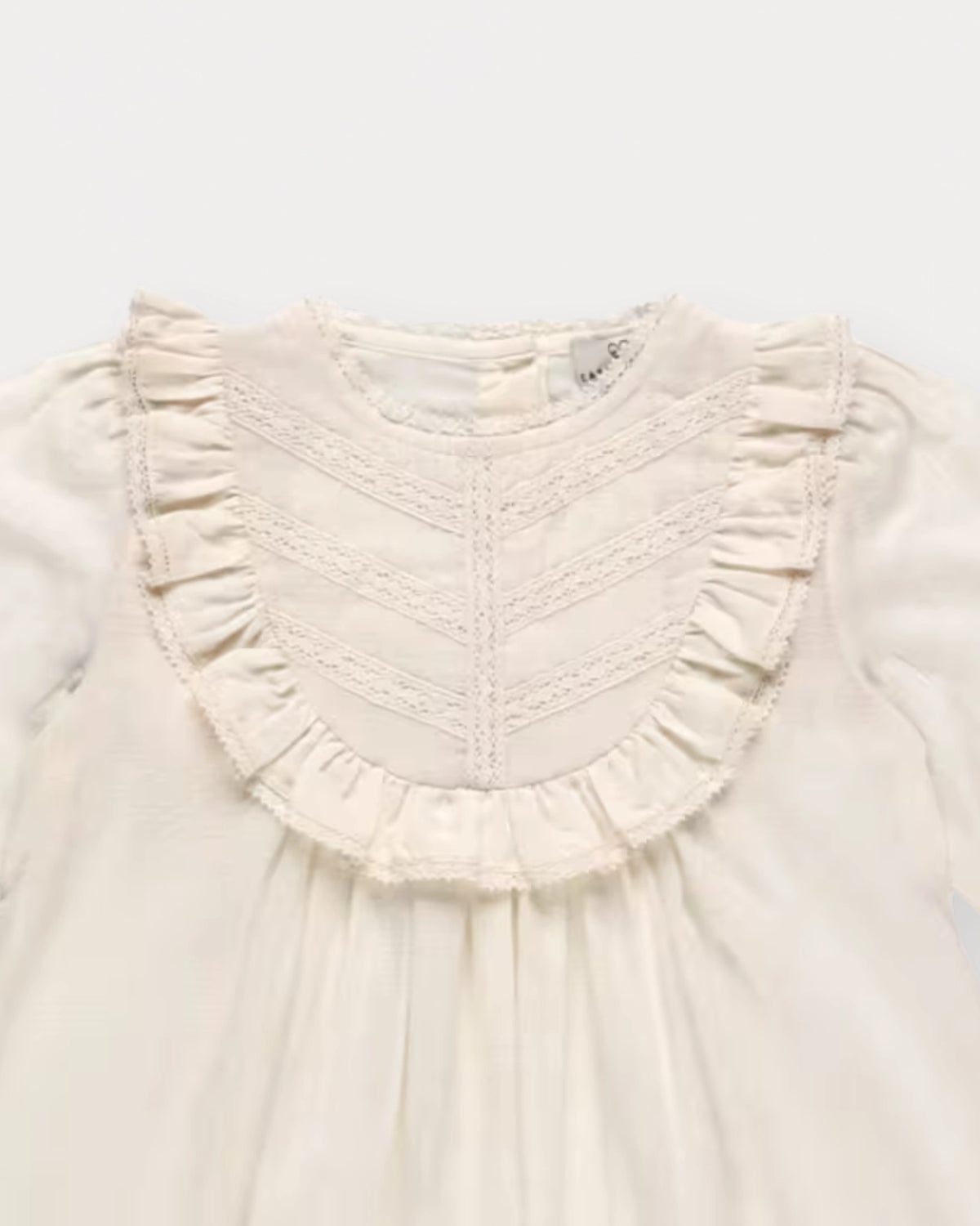 Early Sunday, Lauren Blouse in Plum, made from Printed Cotton Satin fabric, featuring layered lace-trimmed ruffles and delicate pintuck detailing on the yoke, shown in a closeup flat-lay view
