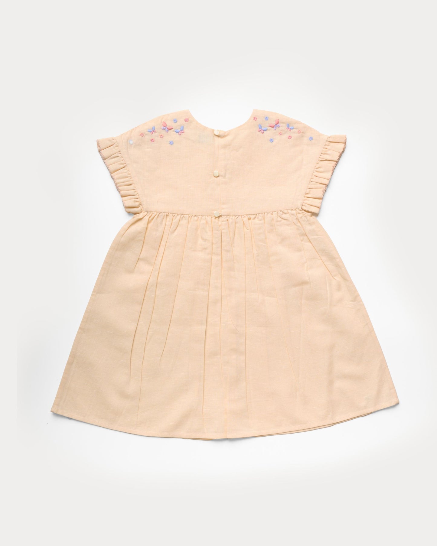 Early Sunday, Lila Dress in Sand color, made from 70% cotton 30% linen solid fabric, featuring Scalloped neckline with contrast stitching, flutter sleeves, gentle gathers, and embroidered hem detail, shown in a back flat-lay view