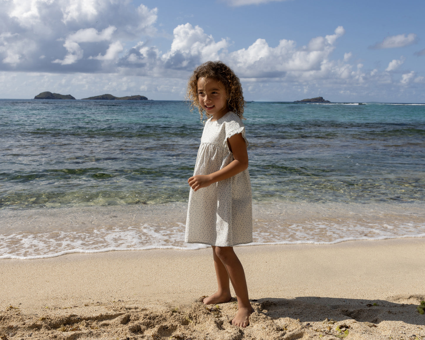 Early Sunday, Lila Dress in Mini Flower print, made from Printed canvas 70% Cotton 30% Linen fabric, featuring a flattering mini dress with a relaxed fit, designed for comfort and effortless style, shown in a side view of model wearing outdoors