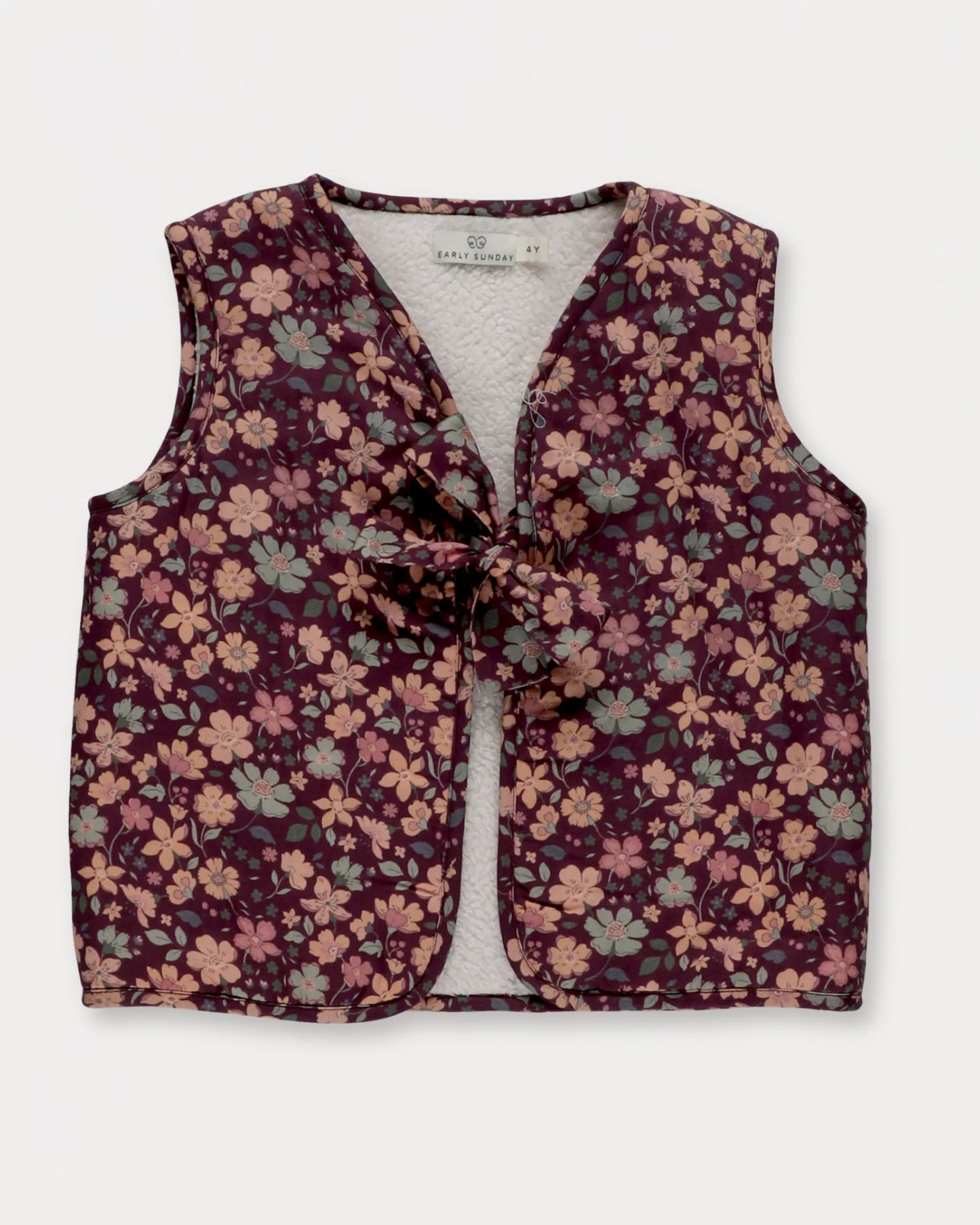 Early Sunday, Lou Vest jacket in Plum, made from Printed Cotton Satin fabric, featuring sleeveless quilted silhouette with tie-up bow detailing, shown in a front flat-lay view
