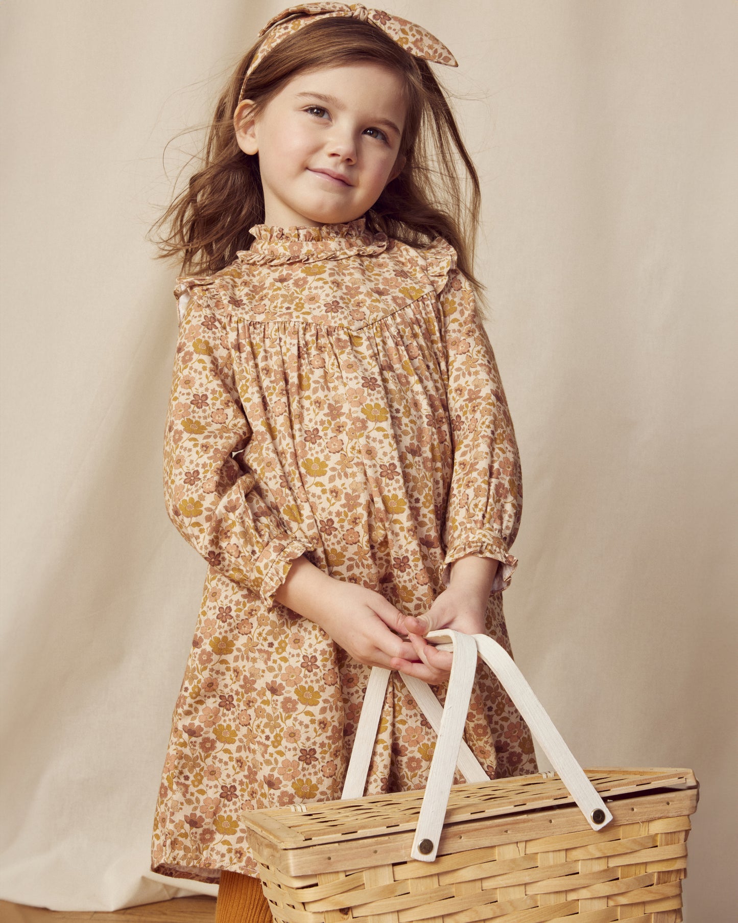 Early Sunday, Louise Dress in Garden Flowers Dusty Pink, made from Printed Cotton Satin fabric, featuring classic silhouette with a charming print, shown in a front view of a model wearing it in a studio setting