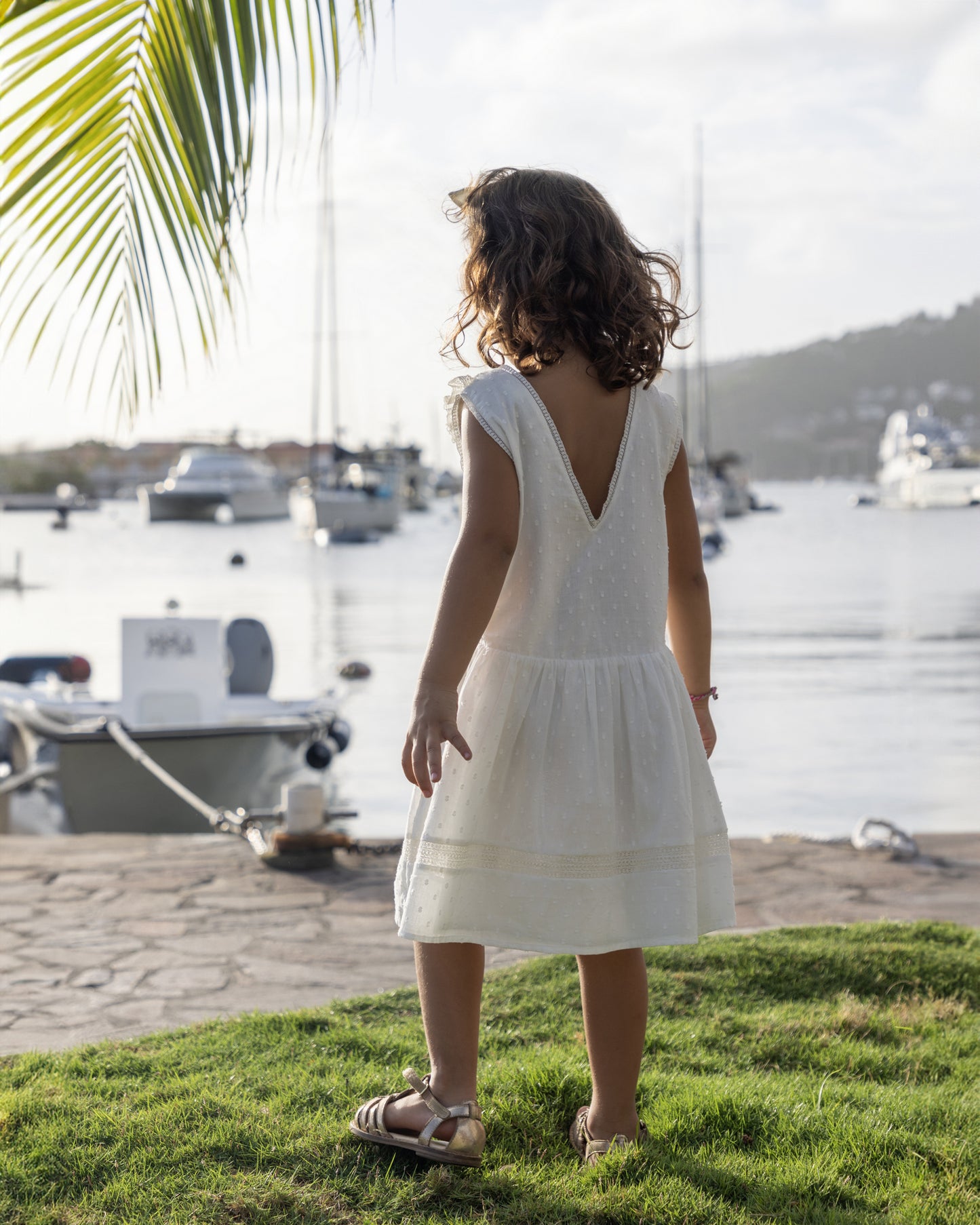 Early Sunday, LYS Dress in Ivory color, made from Cotton Dobby Swiss Dots fabric, featuring flattering fit with delicate finishes, combining style and functionality for an effortlessly elegant look, shown in a back view of model wearing it