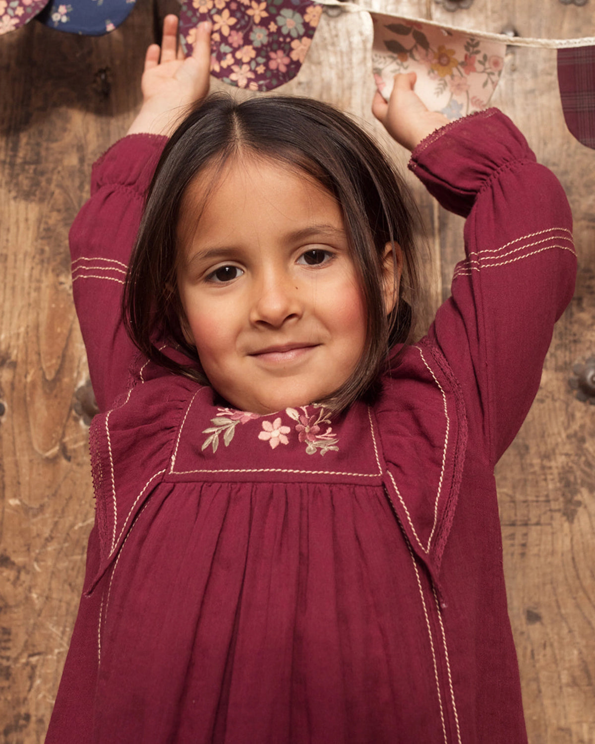 Early Sunday, Margot Dress in Plum, made from Cotton Double Gauze fabric, featuring classic silhouette with ruffle detailing around the sleeves, shown in a close up shot of model wearing it