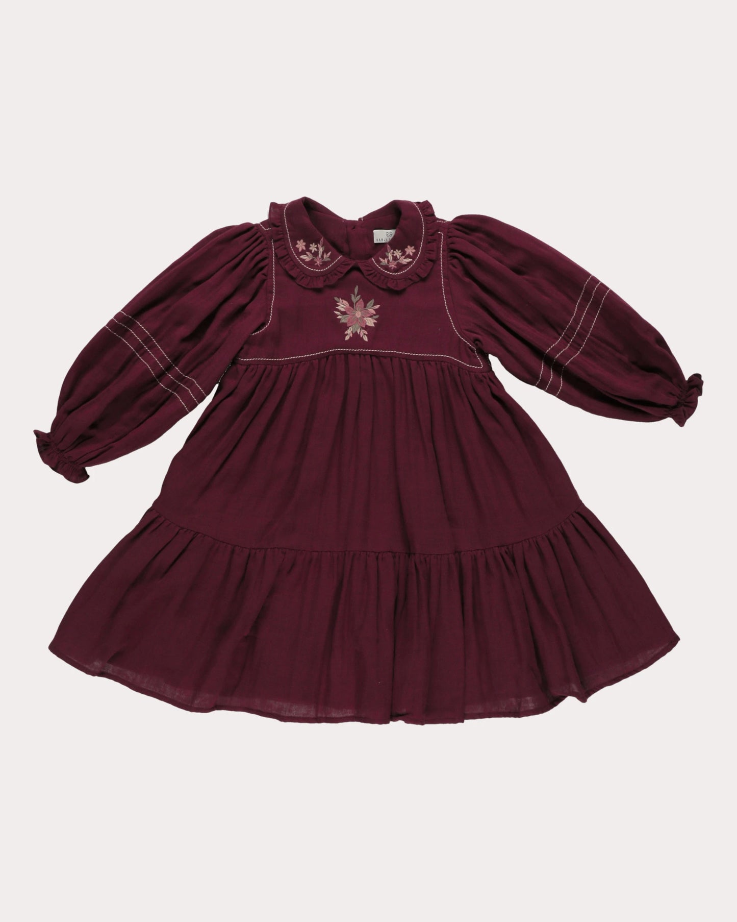 Early Sunday, Marguerite Dress in Plum, made from Cotton Double Gauze fabric, featuring floral embroidery with frilled Peter Pan collar, shown in a front flat-lay view