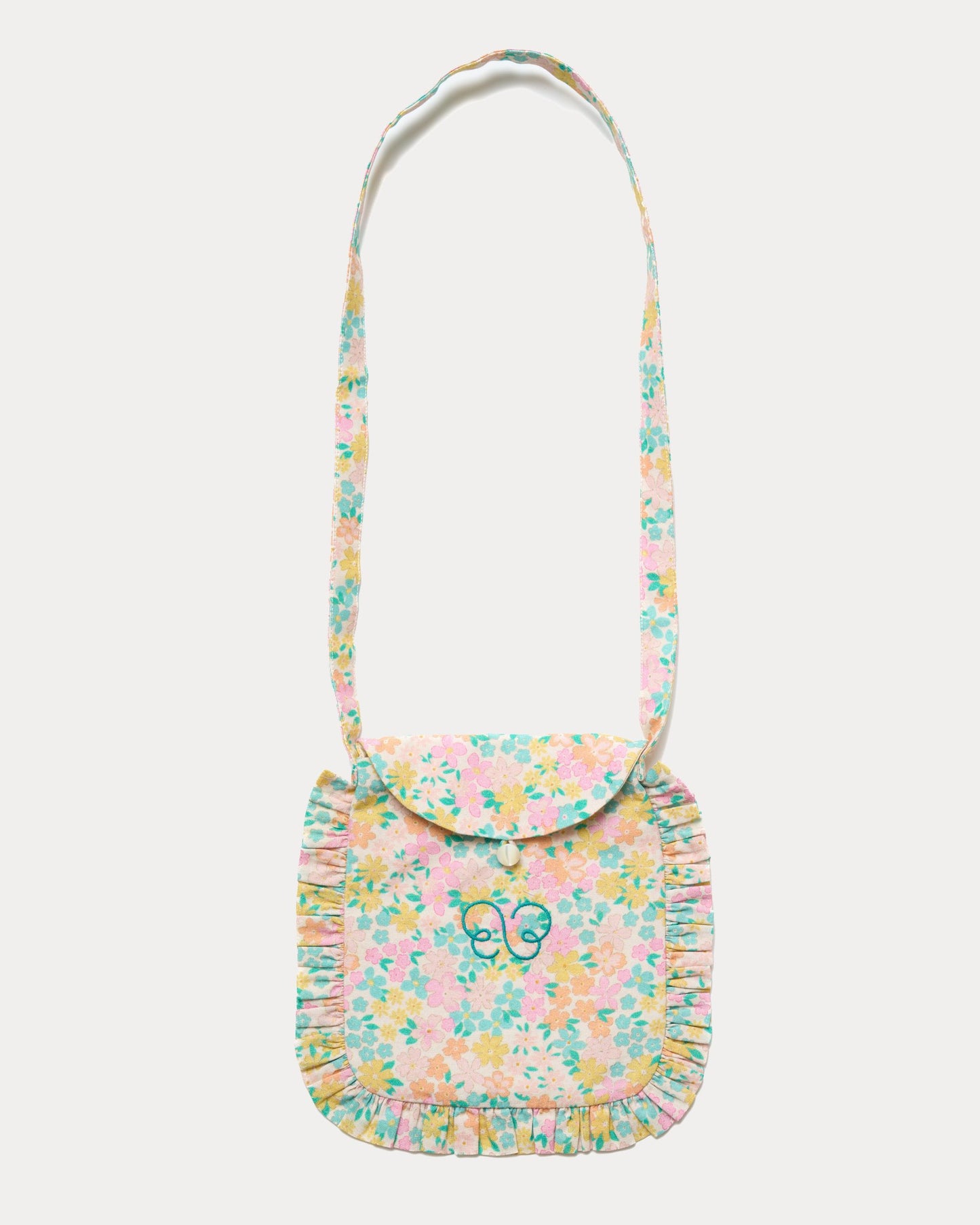 Early Sunday, Miss Sunday Sling in Emma Floral Mint color, made from Organic Printed Cotton Cambric fabric, featuring a frill detailed sling purse with flap closure, shown in front flat-lay view