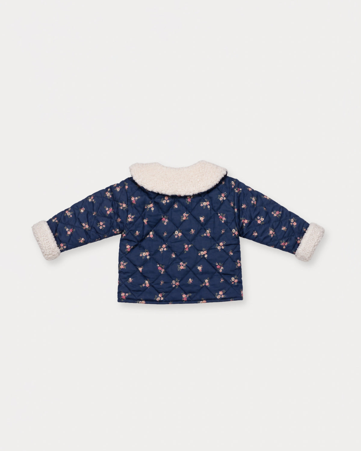 Early Sunday, Molly Baby Quilted Jacket in Ditsy Bouquet Navy, made from Printed Cotton Satin fabric, featuring a sherpa collar & cuffed sleeves, shown in a back flat-lay view