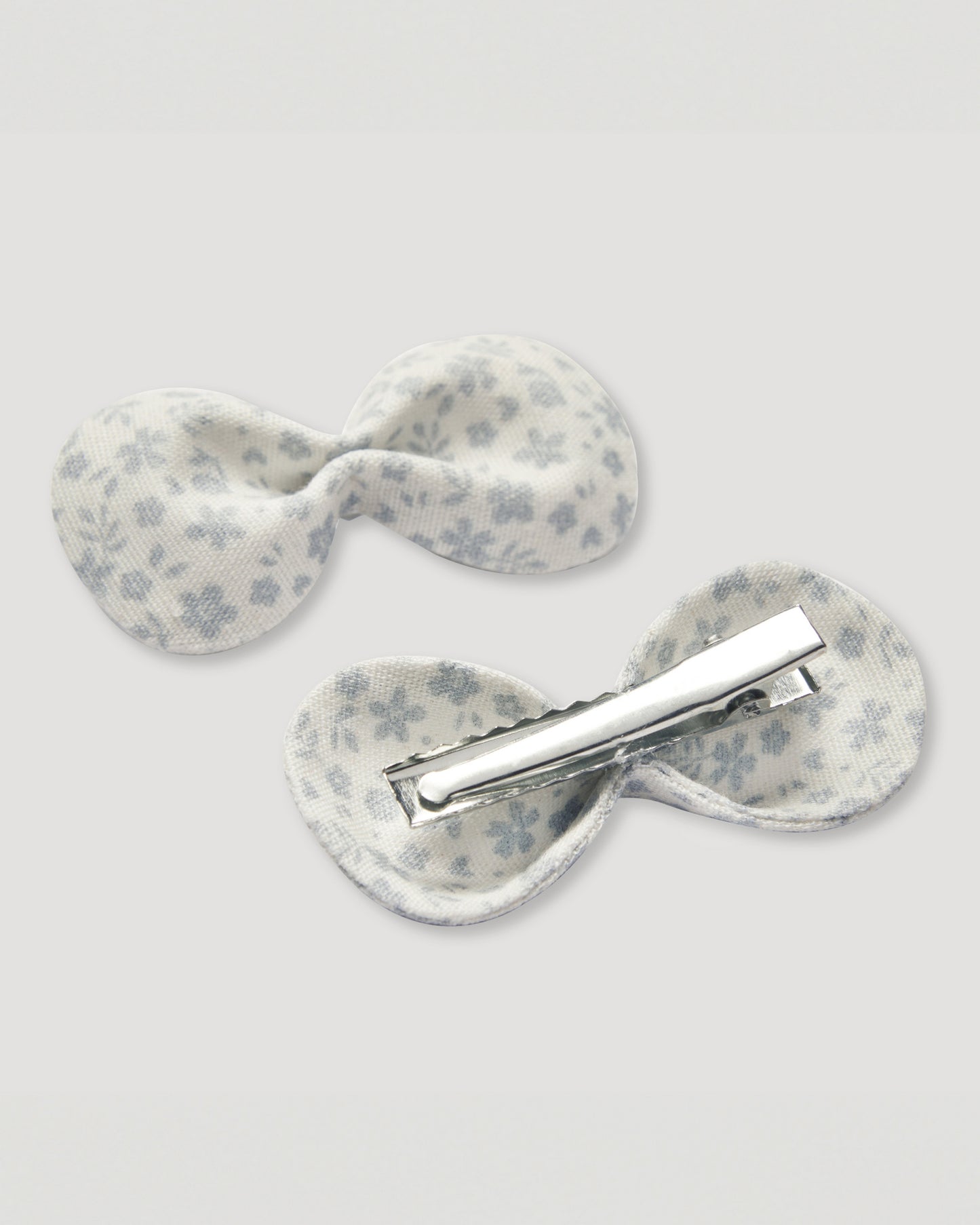 Early Sunday, Penelope Alligator Clip in Mini Flower print, made from Printed canvas 70% Cotton 30% Linen fabric, featuring a fabric bow design with a secure hair clip fastening, shown in a back flat-lay view