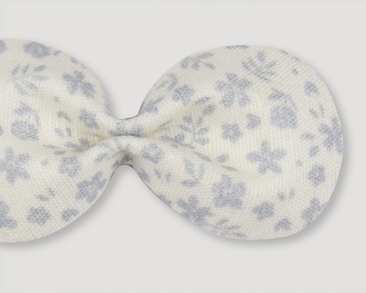 Early Sunday, Penelope Alligator Clip in Mini Flower print, made from Printed canvas 70% Cotton 30% Linen fabric, featuring a fabric bow design with a secure hair clip fastening, shown in a closeup flat-lay view