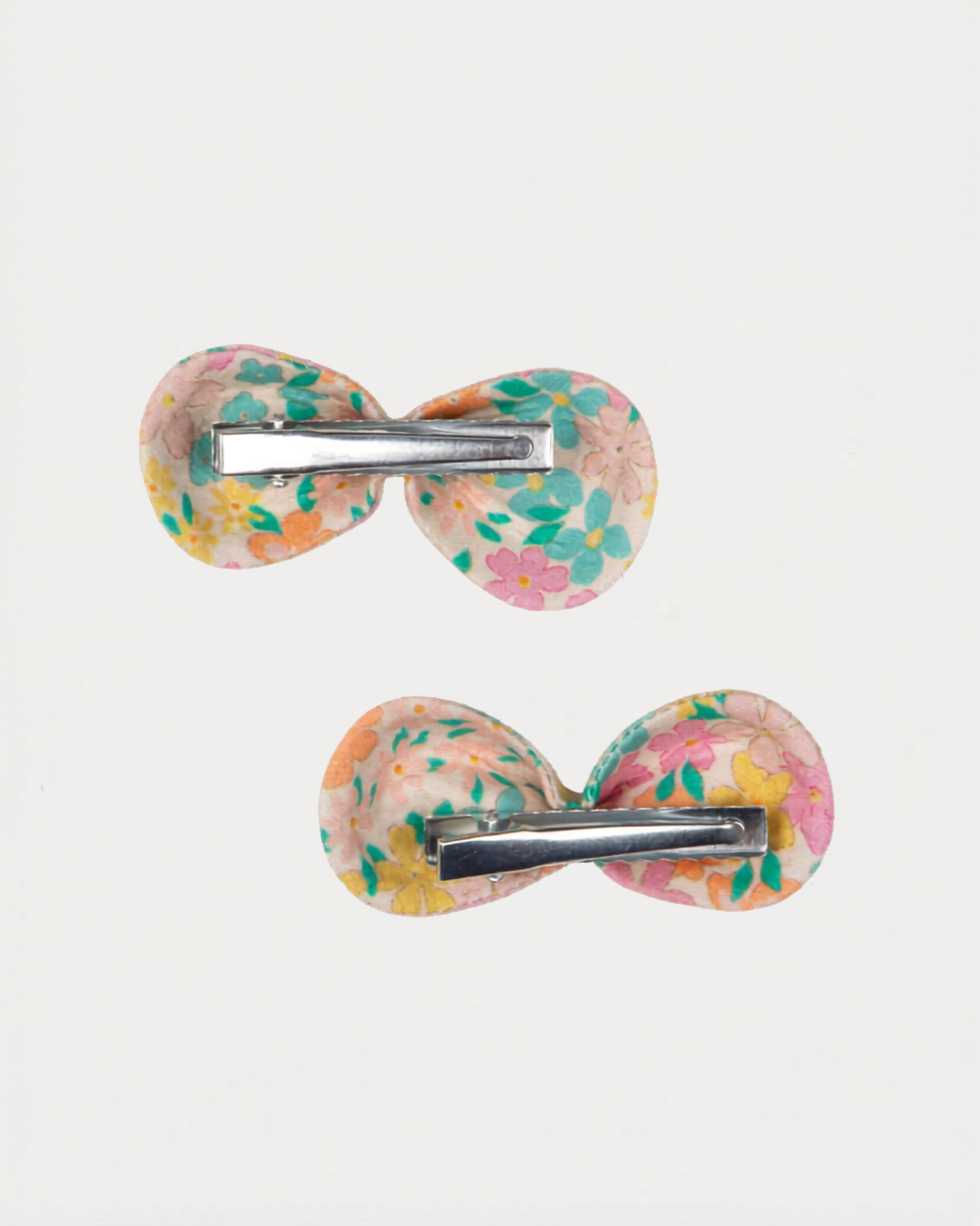 Early Sunday, Penelope Clip in Emma Floral Mint color, made from Organic Printed Cotton Cambric fabric, featuring a set of two bow clips with a secure fit, shown in back flat-lay view