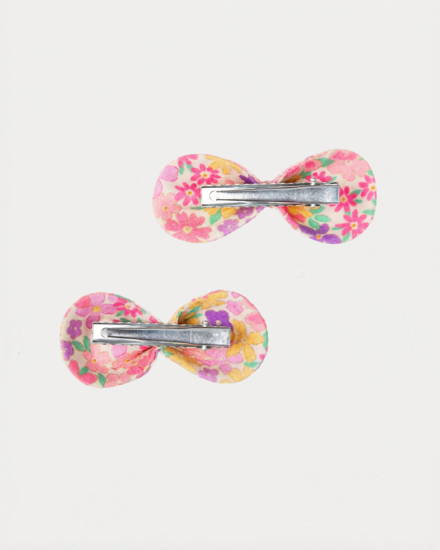 Early Sunday, Penelope Clip in Emma Floral Purple color, made from Organic Printed Cotton Cambric fabric, featuring a set of two bow clips with a secure fit, shown in back flat-lay view