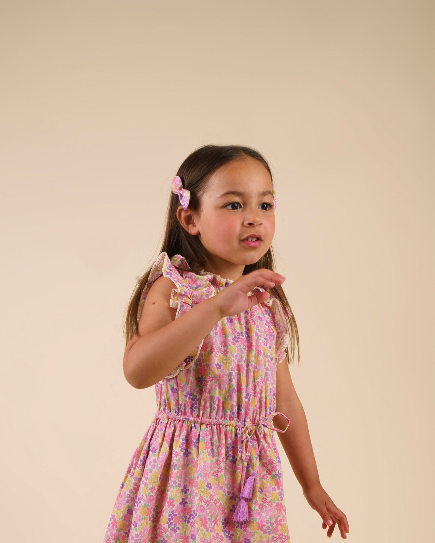Early Sunday, Penelope Clip in Emma Floral Purple color, made from Organic Printed Cotton Cambric fabric, featuring a set of two bow clips with a secure fit, shown in side view of model wearing it