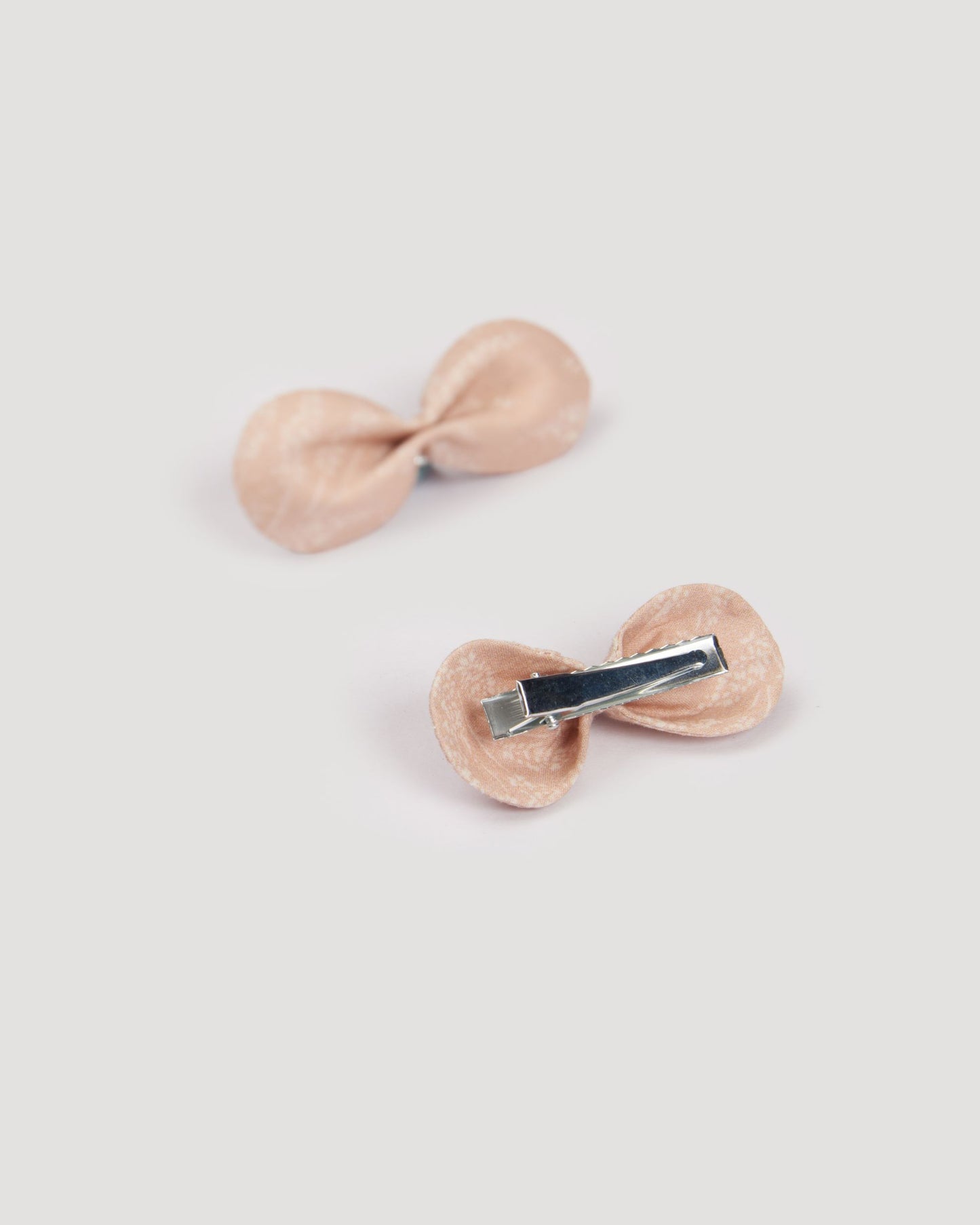 Early Sunday, Penelope Clip in Feather print, made from Printed 60s Cotton Cambric fabric, featuring a set of two bow clips with a secure fit, shown in a back flat-lay view
