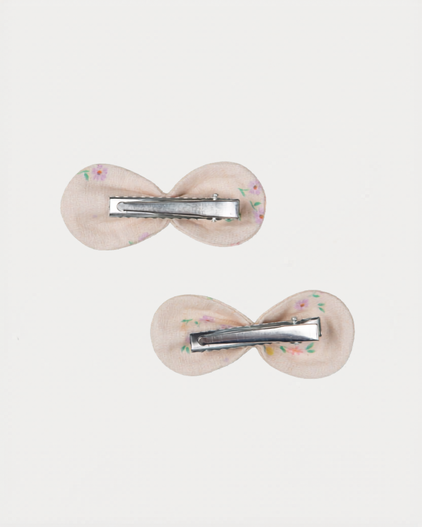 Early Sunday, Penelope Clip in Painted Bouquet print, made from Printed 70% Cotton, 30% Linen fabric, featuring a set of two bow clips with a secure fit, shown in a back flat-lay view