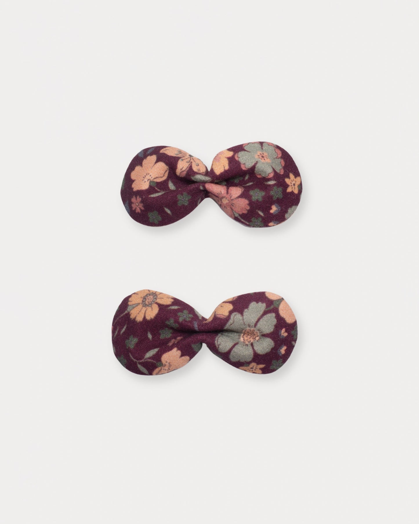 Early Sunday, Penelope Clip in Garden Flowers Plum, made from Printed Cotton Satin fabric, featuring a set of two bow clips with a secure fit, shown in a front flat-lay view