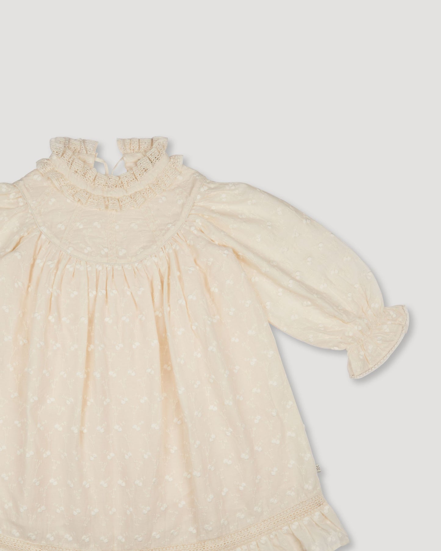 Early Sunday, Penelope Dress in Hazelnut Cream, made from All-Over Embroidered Cotton Cambric fabric, featuring Hand-embroidered floral motifs, shown in a closeup flat-lay view