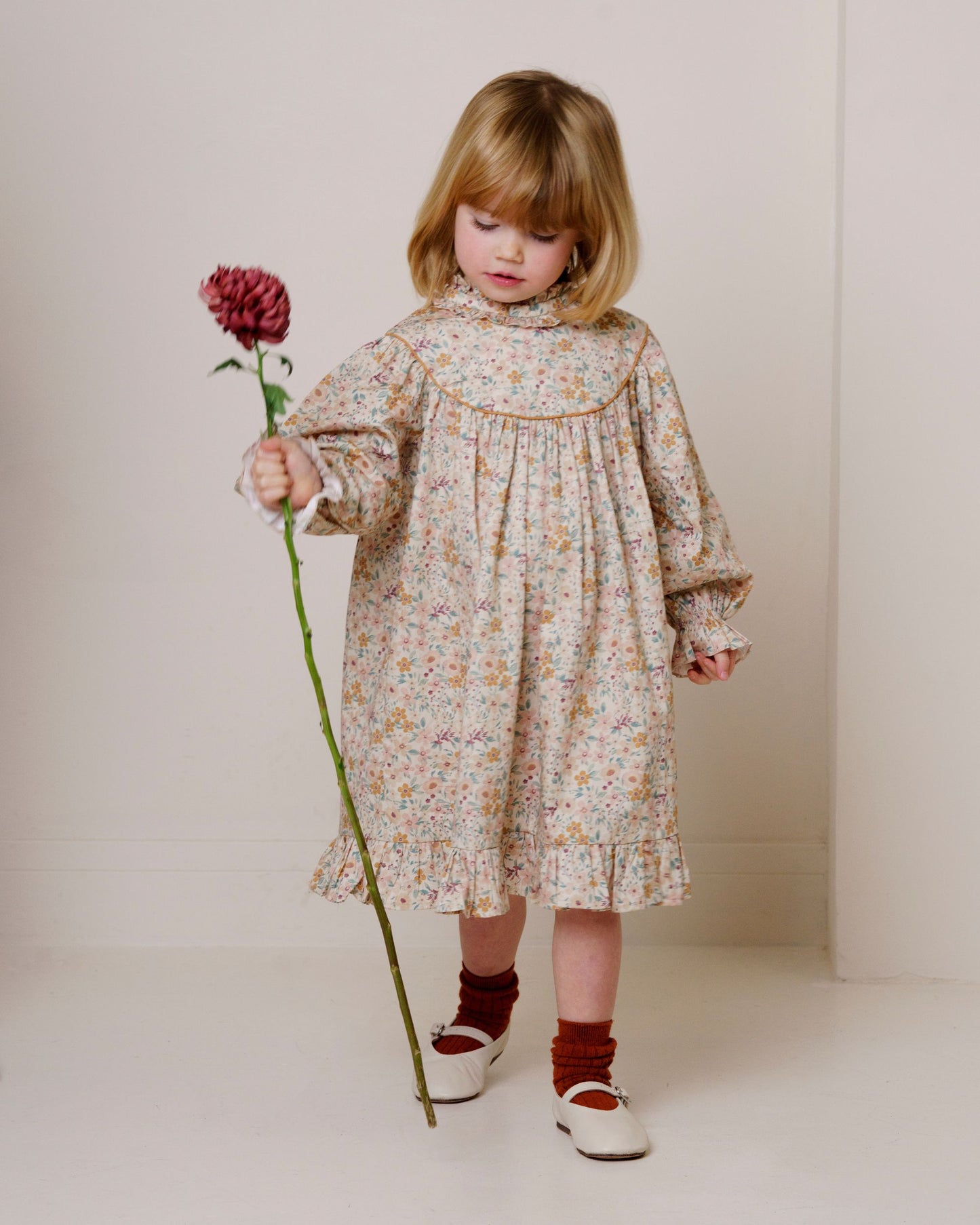 Early Sunday, Penelope Dress in Floral print, made from Printed Cotton Satin fabric, featuring Hand-embroidered floral motifs, shown in a front view of a model wearing it in a studio setting
