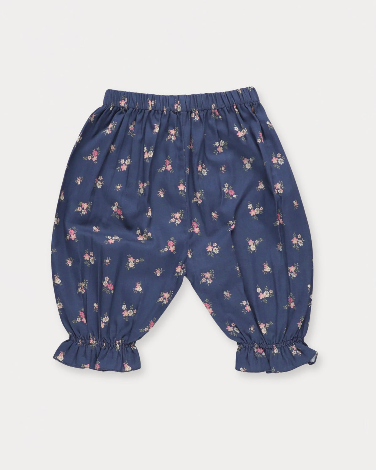 Early Sunday, Poppy Baby Bloomer Trousers in Ditsy Bouquet Navy, made from Printed Cotton Satin fabric, featuring an elasticated waistband & ruffled cuffs at the ankles, shown in a front flat-lay view