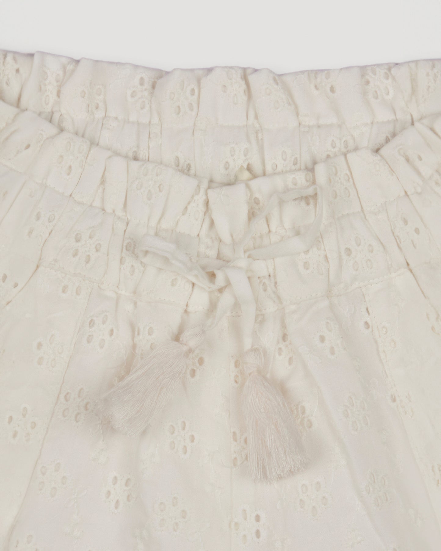 Early Sunday, Roman Shorts in Ivory color, made from All-Over Eyelet Embroidered Cotton Schifflie fabric, featuring relaxed fit with delicate finishes, combining style and functionality, shown in a closeup flat-lay view