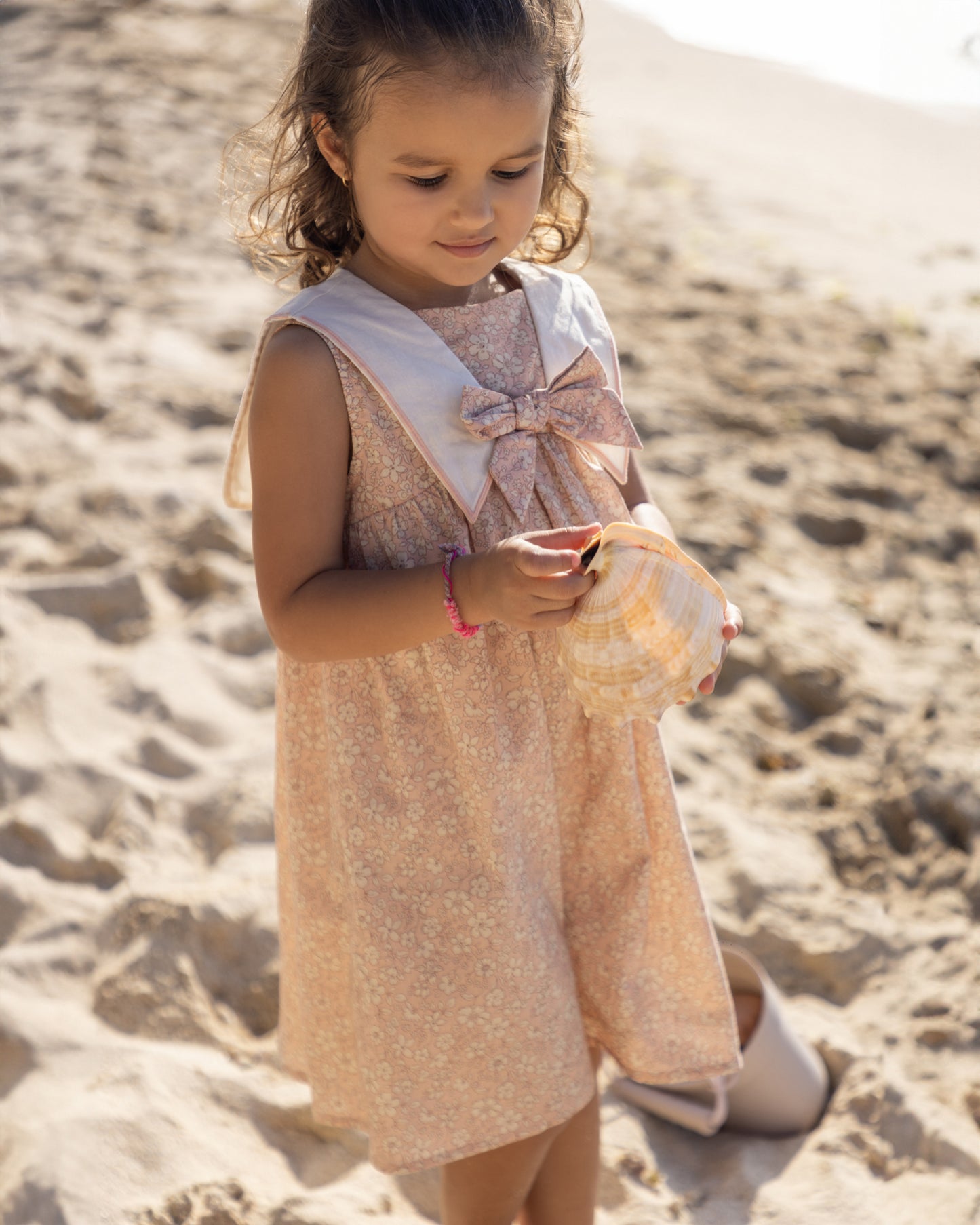 Early Sunday, Sabrina Dress in Garden Flowers print, made from Printed Cotton Cambric fabric, featuring flattering fit with delicate finishes, combining style and functionality for an effortlessly elegant look, shown in an outdoor shot of model wearing it