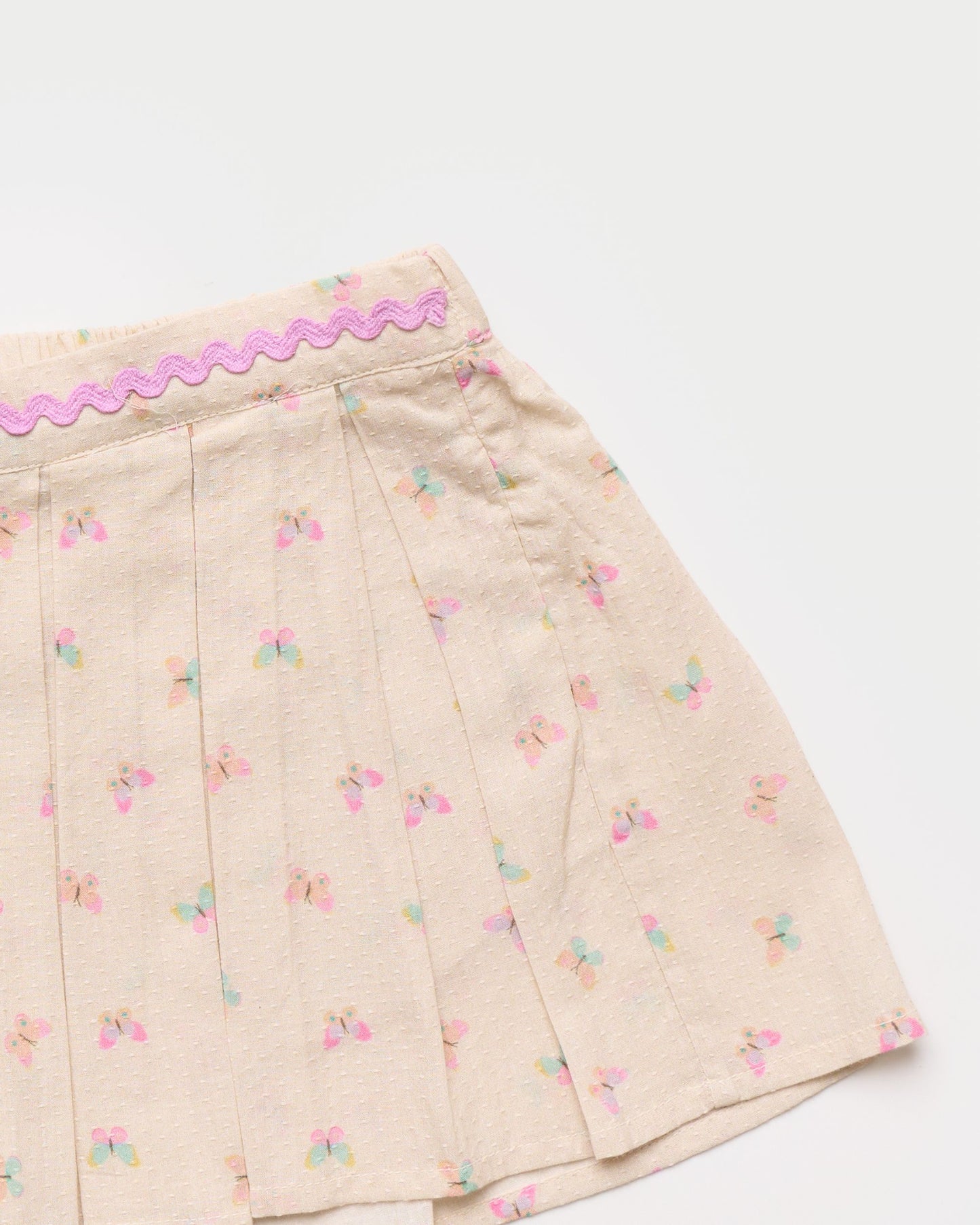 Early Sunday, Solal Skort in Butterflies print, made from Printed Cotton Tiny Swiss Dobby fabric, featuring a flared skirt overlay with attached shorts & elastic waistband, shown in a closeup flat-lay view