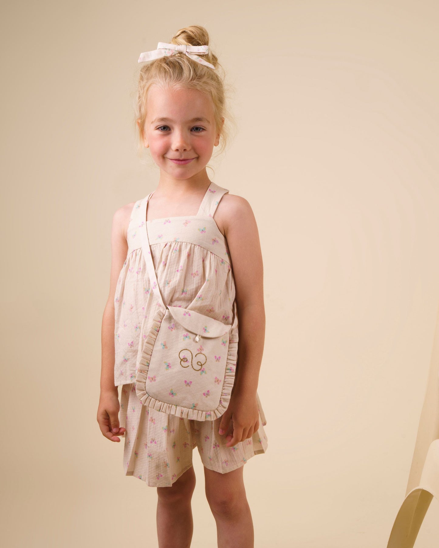 Early Sunday, Solal Skort in Butterflies print, made from Printed Cotton Tiny Swiss Dobby fabric, featuring a flared skirt overlay with attached shorts & elastic waistband, shown in an angled view of a model wearing it in a studio setting