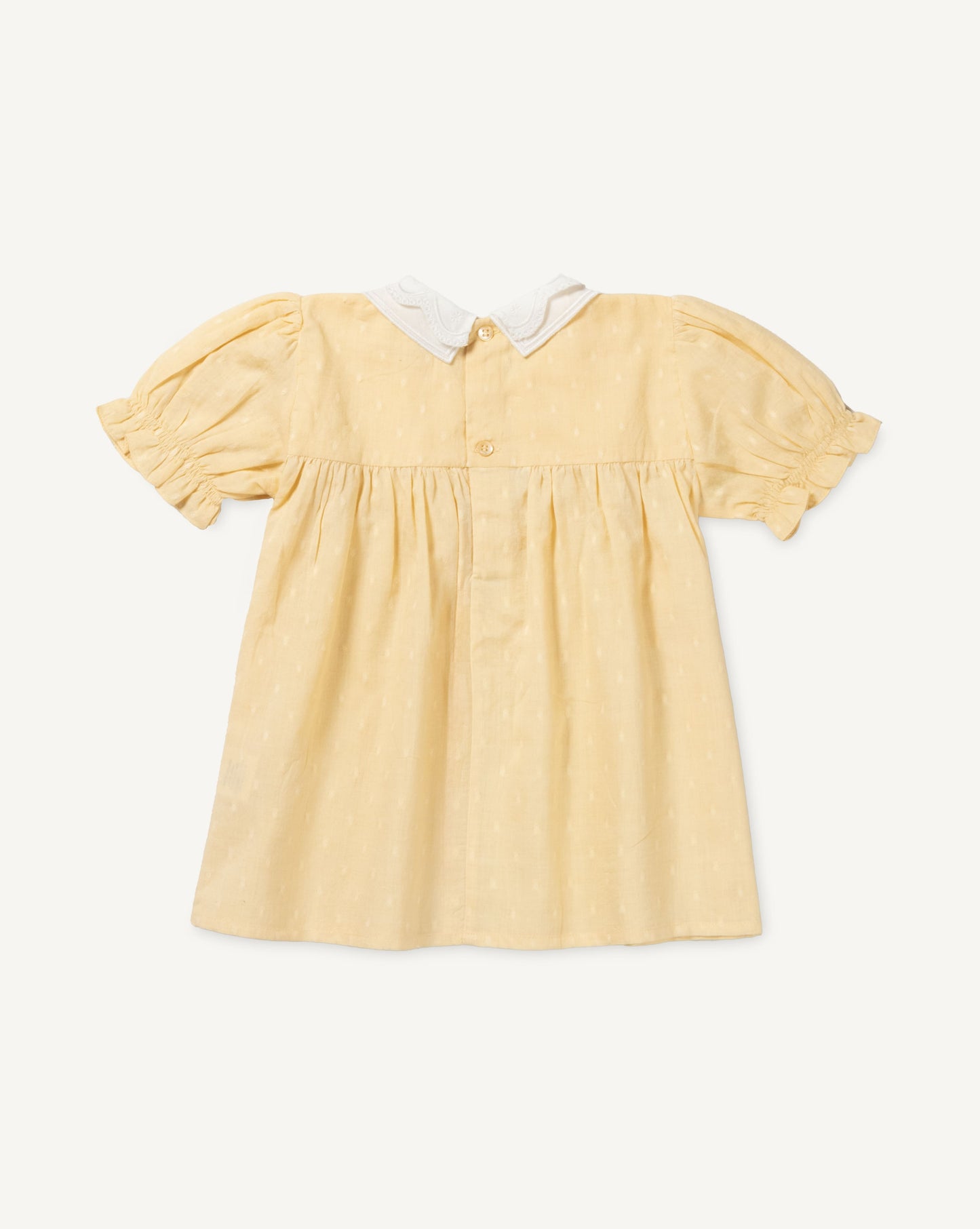 Early Sunday, Sukie Baby Dress & Bloomer in Vanilla color, made from Cotton Dobby Swiss Dots fabric, featuring flared dress with a relaxed fit for ease of movement, matching bloomer with an elasticated waistband for comfort and flexibility., shown in a back flat-lay view