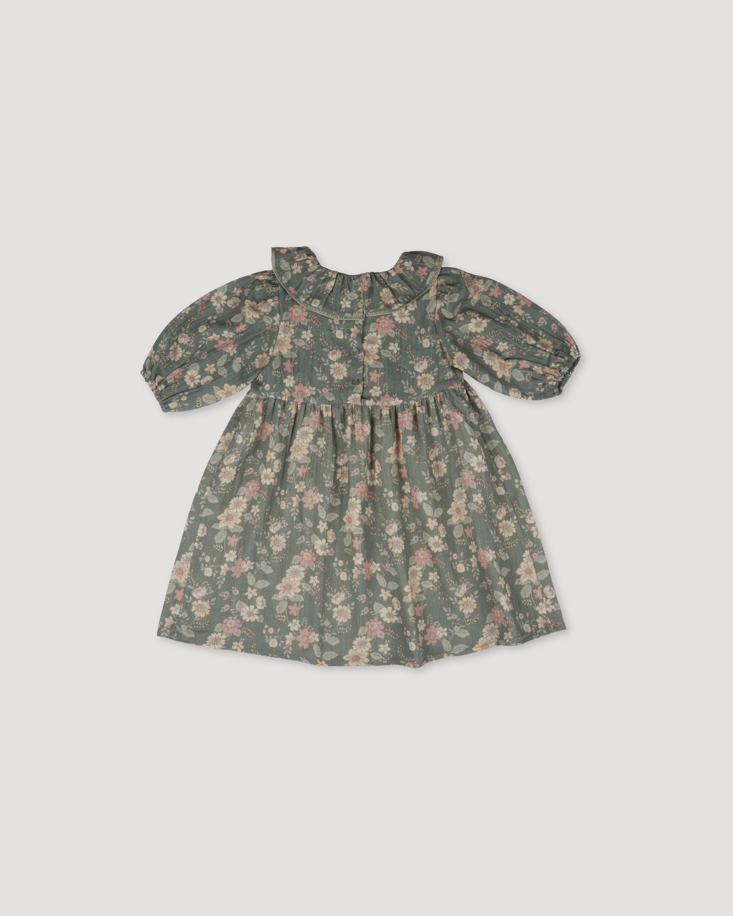 Early Sunday, Suzie Dress in Autumn Bloom Soft Green, made from Printed Cotton Double Gauze fabric, featuring classic silhouette with a ruffle neckline and mother-of-pearl buttons, shown in a front flat-lay view