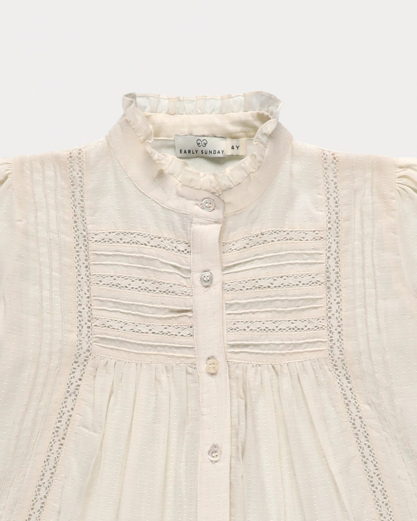 Early Sunday, Zoe Shirt in Ecru, made from Cotton Jeera Dobby Voile fabric, featuring frilled roundneck with detailed lace yoke, shown in a closeup flat-lay view
