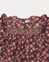 Early Sunday, Ellie Baby Dress & Bloomer Set in Garden Flowers Plum, made from Printed Cotton Satin fabric, featuring frilly sleeves across shoulder & smocked chest, shown in a closeup flat-lay view