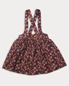 Early Sunday, Annie Skirt in Garden Flowers Plum, made from Printed Cotton Satin fabric, featuring an A-line silhouette with adjustable cross-back straps and soft gathers, shown in a back flat-lay view