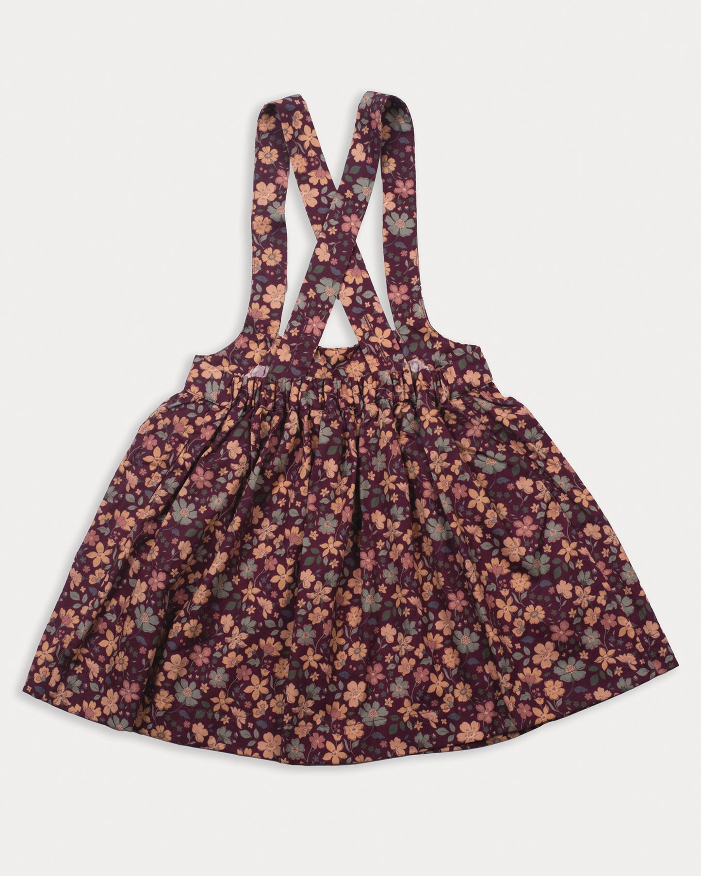 Early Sunday, Annie Skirt in Garden Flowers Plum, made from Printed Cotton Satin fabric, featuring an A-line silhouette with adjustable cross-back straps and soft gathers, shown in a back flat-lay view