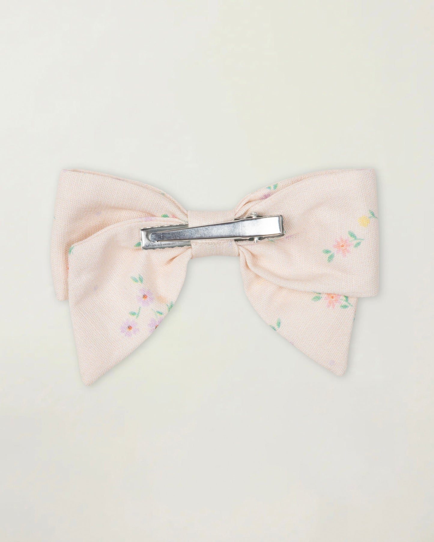 Early Sunday, Chiara Clip in Painted Bouquet print, made from Printed 70% Cotton, 30% Linen fabric, featuring a bow design on an alligator clip with a secure fit, shown in a back flat-lay view