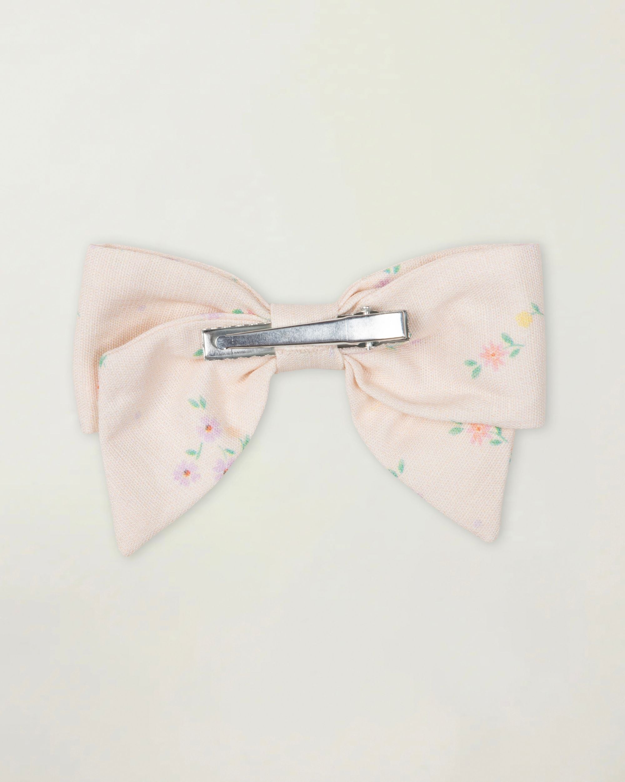 Early Sunday, Chiara Clip in Painted Bouquet print, made from Printed 70% Cotton, 30% Linen fabric, featuring a bow design on an alligator clip with a secure fit, shown in a back flat-lay view