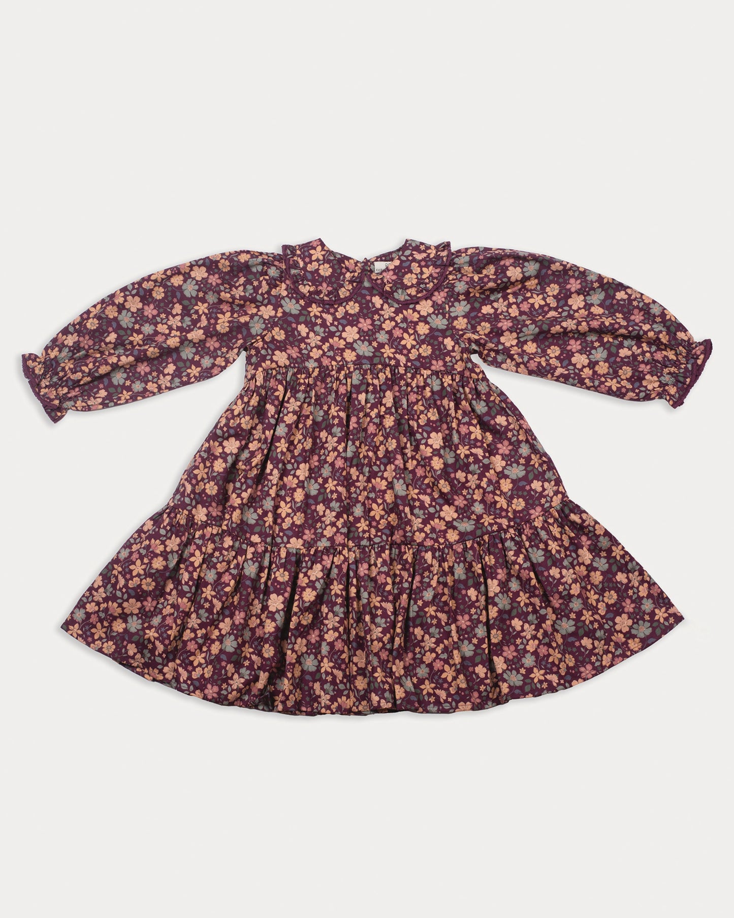 Early Sunday, Marguerite Dress in Garden Flowers Plum, made from Printed Cotton Satin fabric, featuring floral print and detailed lace yoke with Peter Pan collar, shown in a front flat-lay view