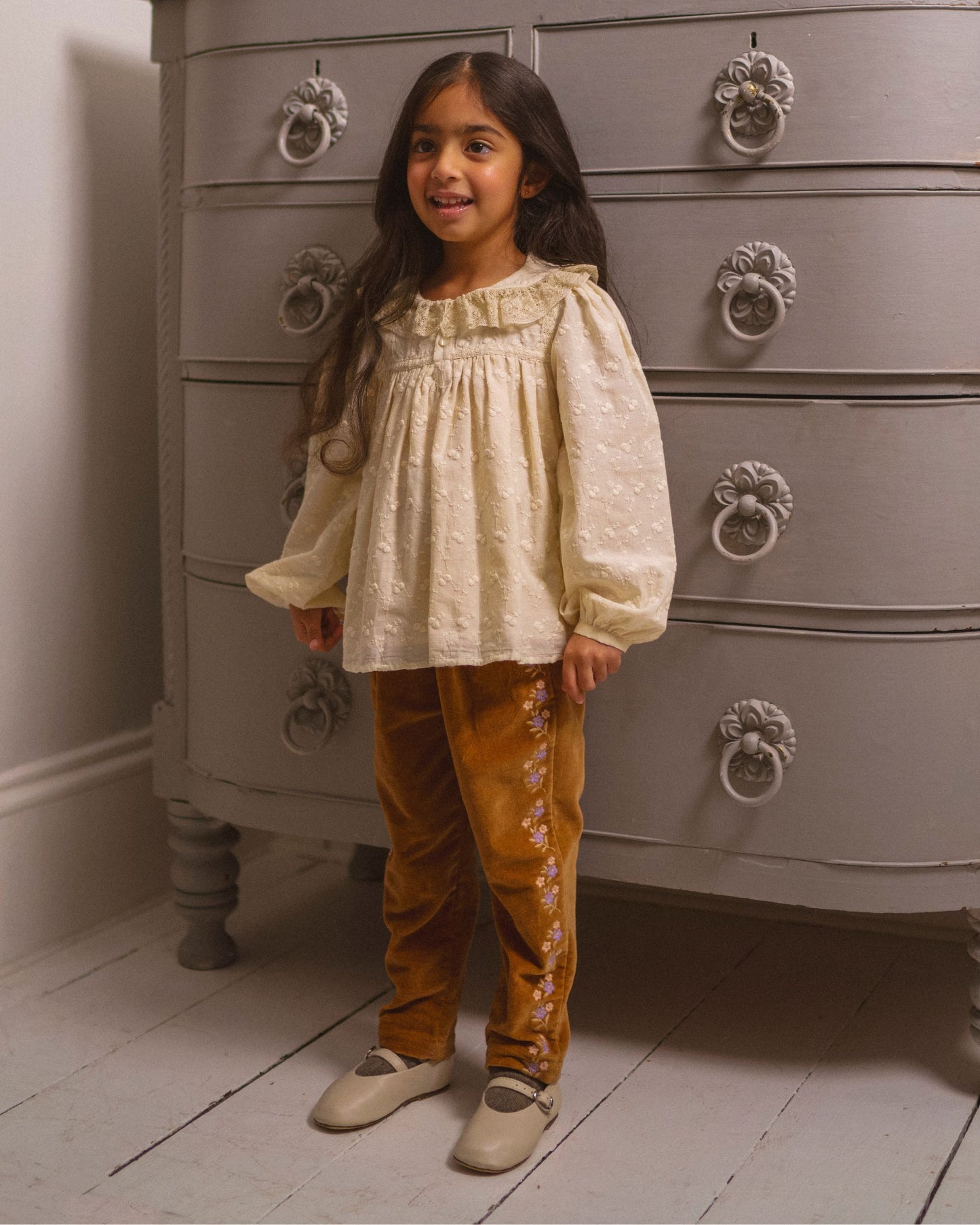 Early Sunday, Adrien Trouser in Almond, made from Dyed Cotton Velvet fabric, featuring Relaxed design with ample room for movement, perfect for active kids, shown in a front view of model wearing it