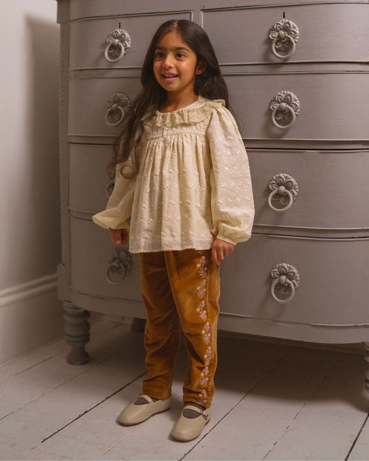 Early Sunday, Adrien Trouser in Almond, made from Dyed Cotton Velvet fabric, featuring Relaxed design with ample room for movement, perfect for active kids, shown in a front view of model wearing it