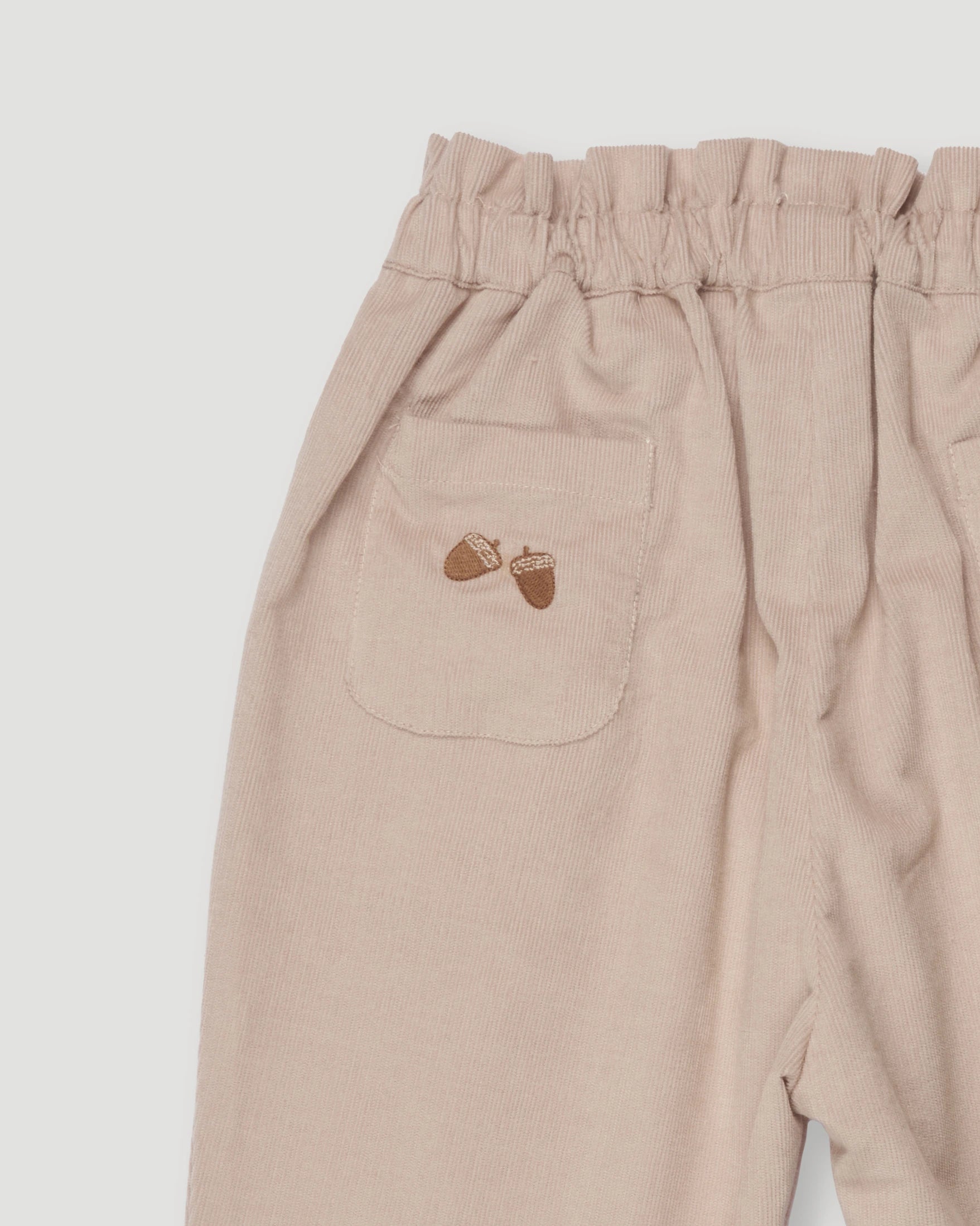 Early Sunday, Adrin Trouser in Beige, made from Cotton Corduroy fabric, featuring a relaxed silhouette with a comfortable elastic waistband, shown in a closeup flat-lay view