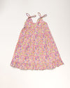 Early Sunday, Alena dress in Emma Floral Purple color, made from organic printed cotton cambric fabric, featuring tie-up shoulder straps, gathered flare, and ruffled hem, shown in a front flat-lay view.