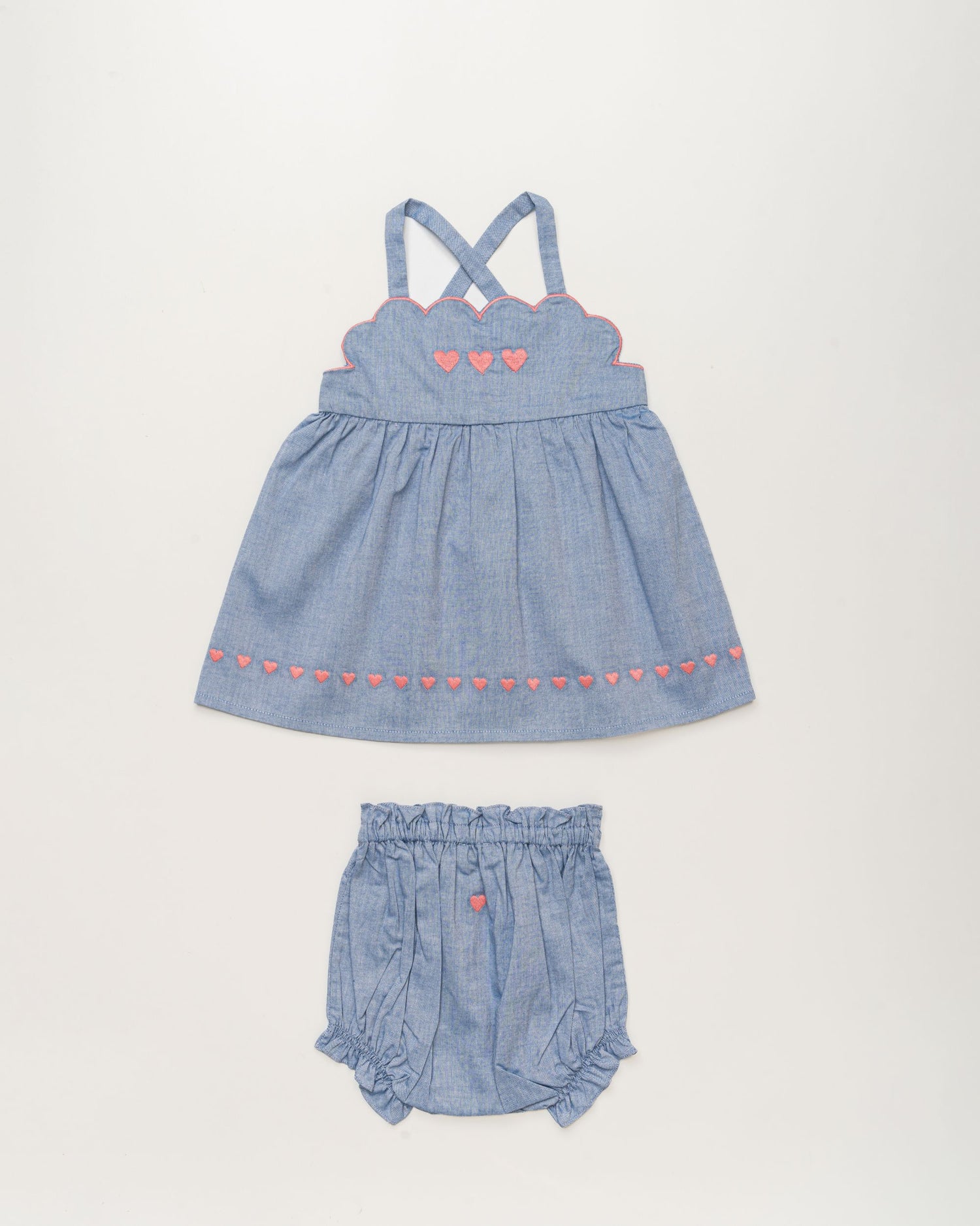 Early Sunday, Alice Baby Dress & Bloomer Set in Summer Sky color, made from 100% Cotton Chambray fabric, featuring a sleeveless design with a smocked bodice & matching bloomers, shown in a front flat-lay view