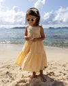 Early Sunday, Alice Dress in Vanilla, made from Cotton Dobby Swiss Dots fabric, featuring sleeveless with adjustable tie-up straps and a tiered silhouette, shown in a front view of model wearing it