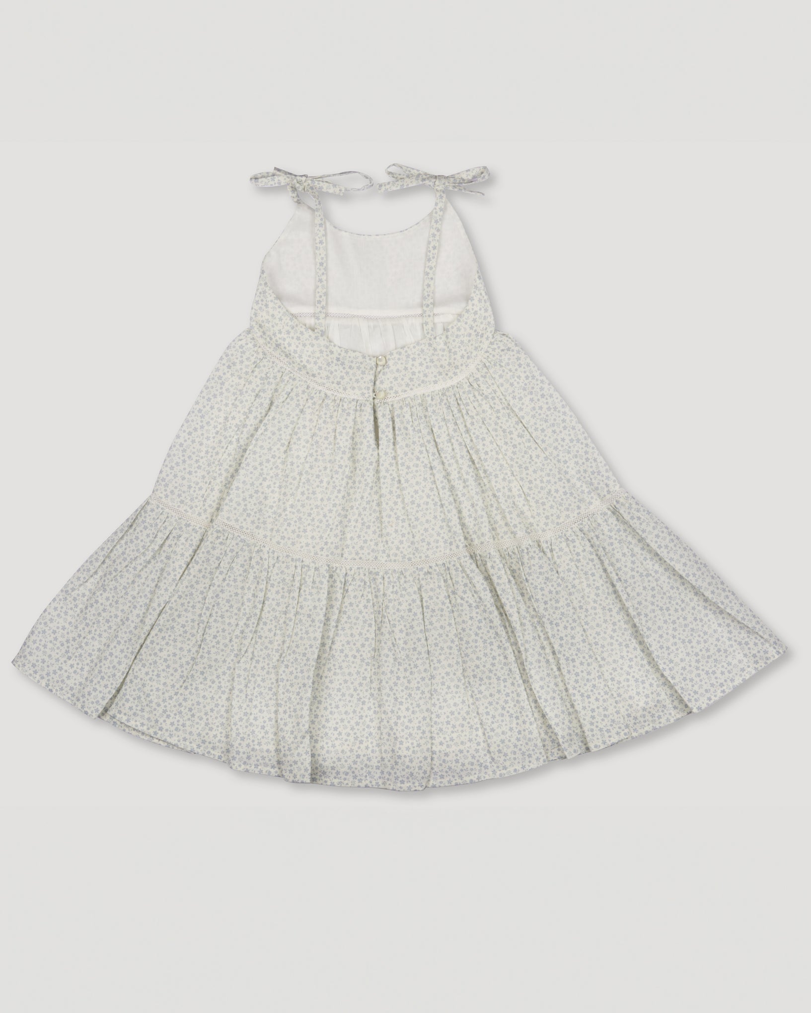 Early Sunday, Alice Dress in Mini Flower print, made from Printed canvas 70% Cotton 30% Linen fabric, featuring sleeveless with adjustable tie-up straps and a tiered silhouette, shown in a back flat-lay view