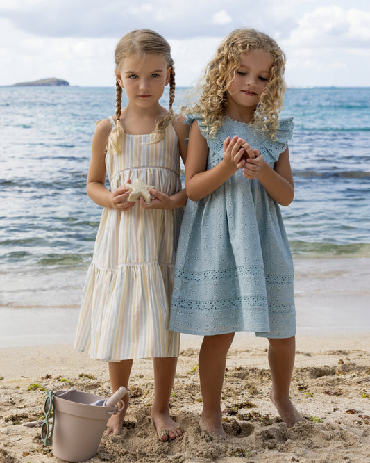 Early Sunday, Alice Dress in Summer Stripe, made from Printed canvas 70% Cotton 30% Linen fabric, featuring sleeveless with adjustable tie-up straps and a tiered silhouette, shown in a front view of model wearing it