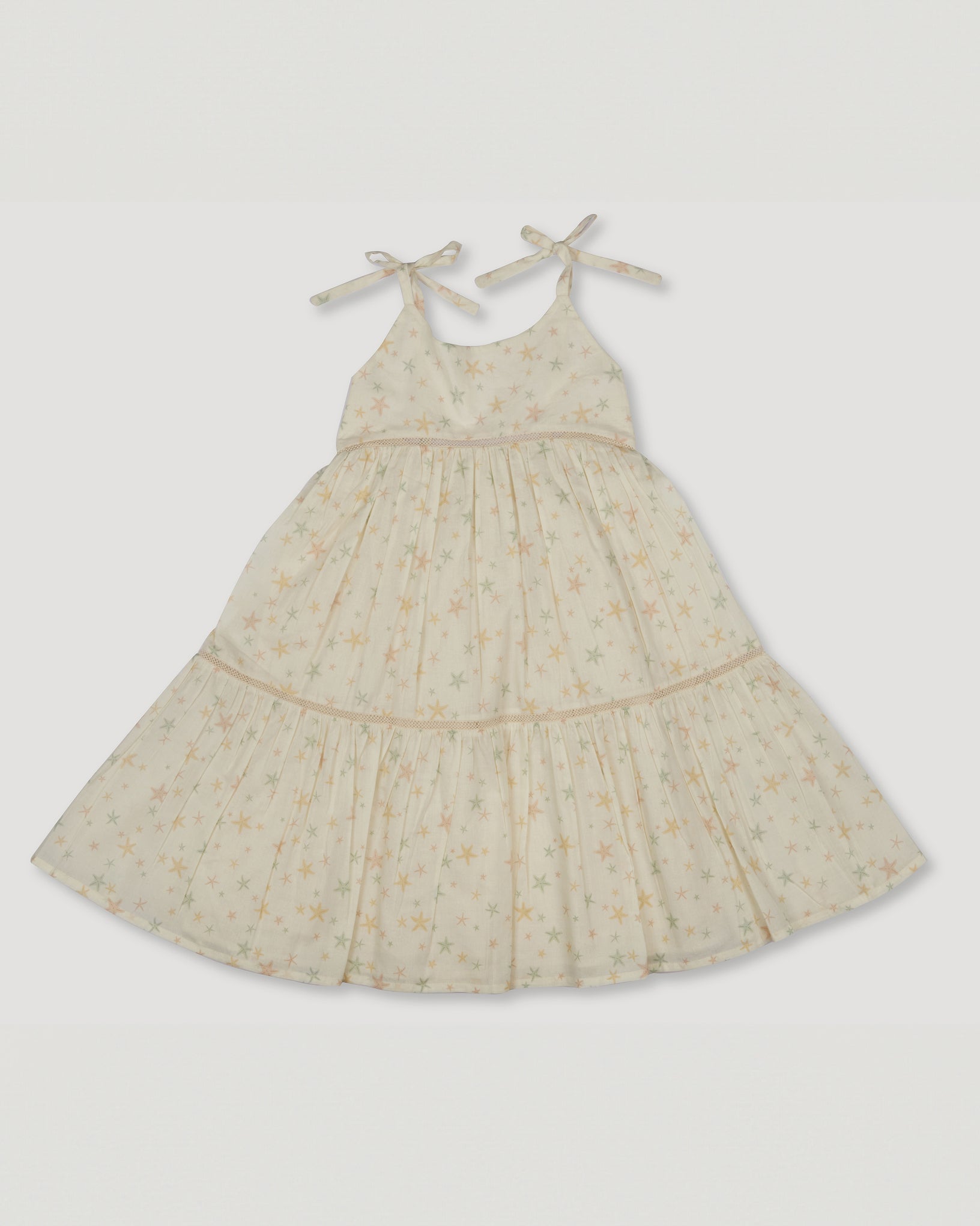 Early Sunday, Alice Dress in Star Fish print, made from Printed Cotton Cambric fabric, featuring sleeveless with adjustable tie-up straps and a tiered silhouette, shown in a front flat-lay view