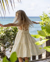 Early Sunday, Alice Dress in Star Fish print, made from Printed Cotton Cambric fabric, featuring sleeveless with adjustable tie-up straps and a tiered silhouette, shown in a back view of model wearing it